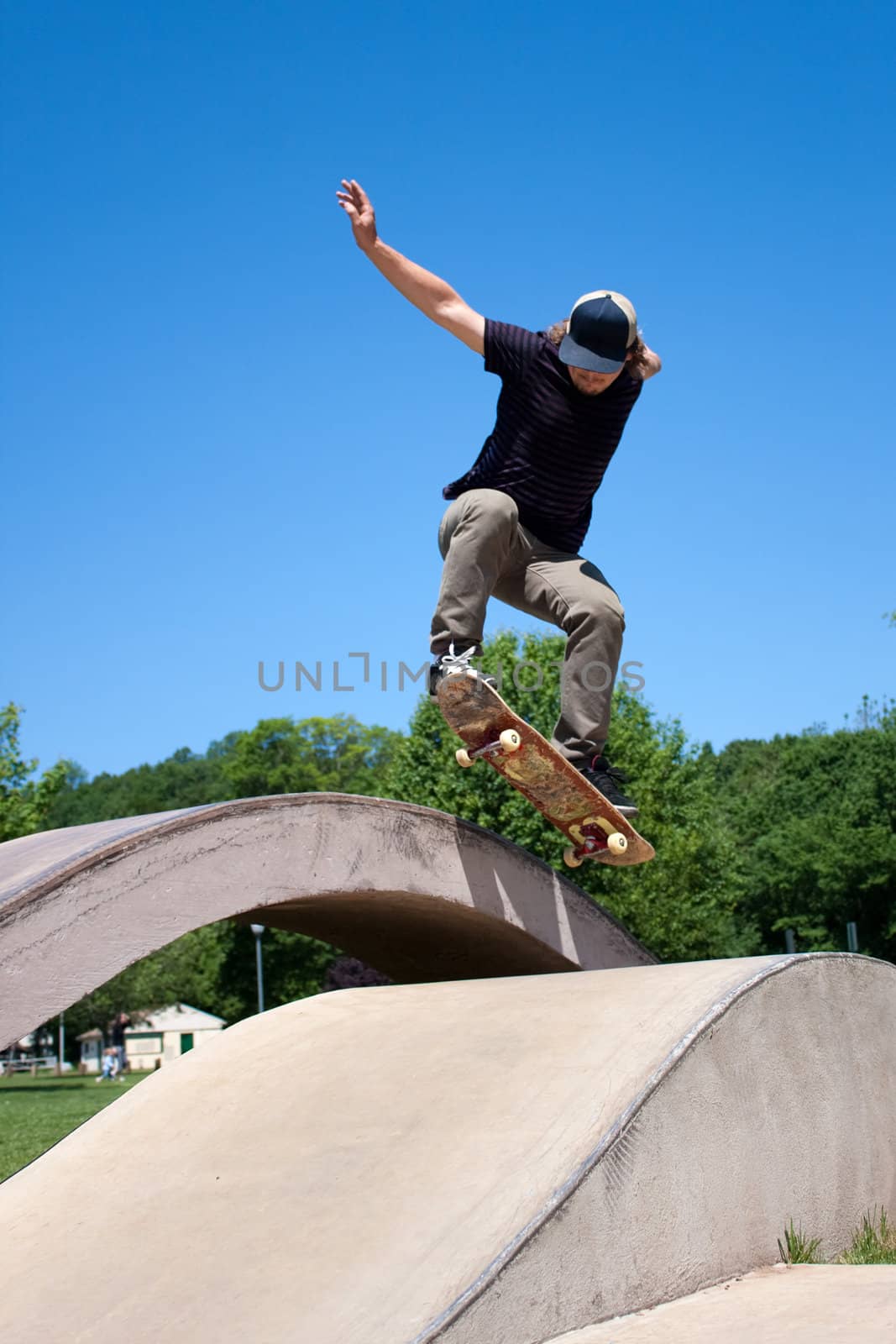 Skateboarder Doing a Jump at a Concrete Skate Park by graficallyminded