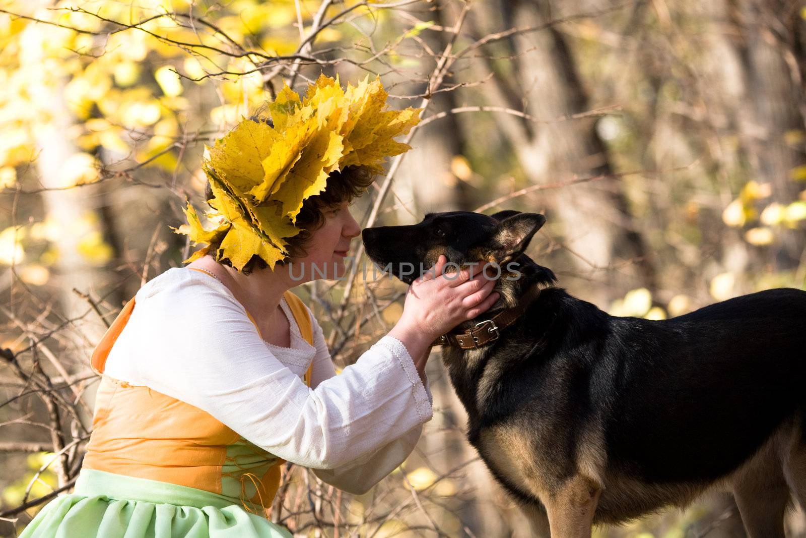 Woman and dog in autumn forest
