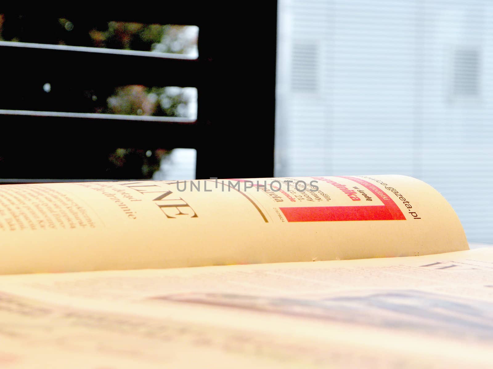 The daily newspaper on the table. Window in the background. 