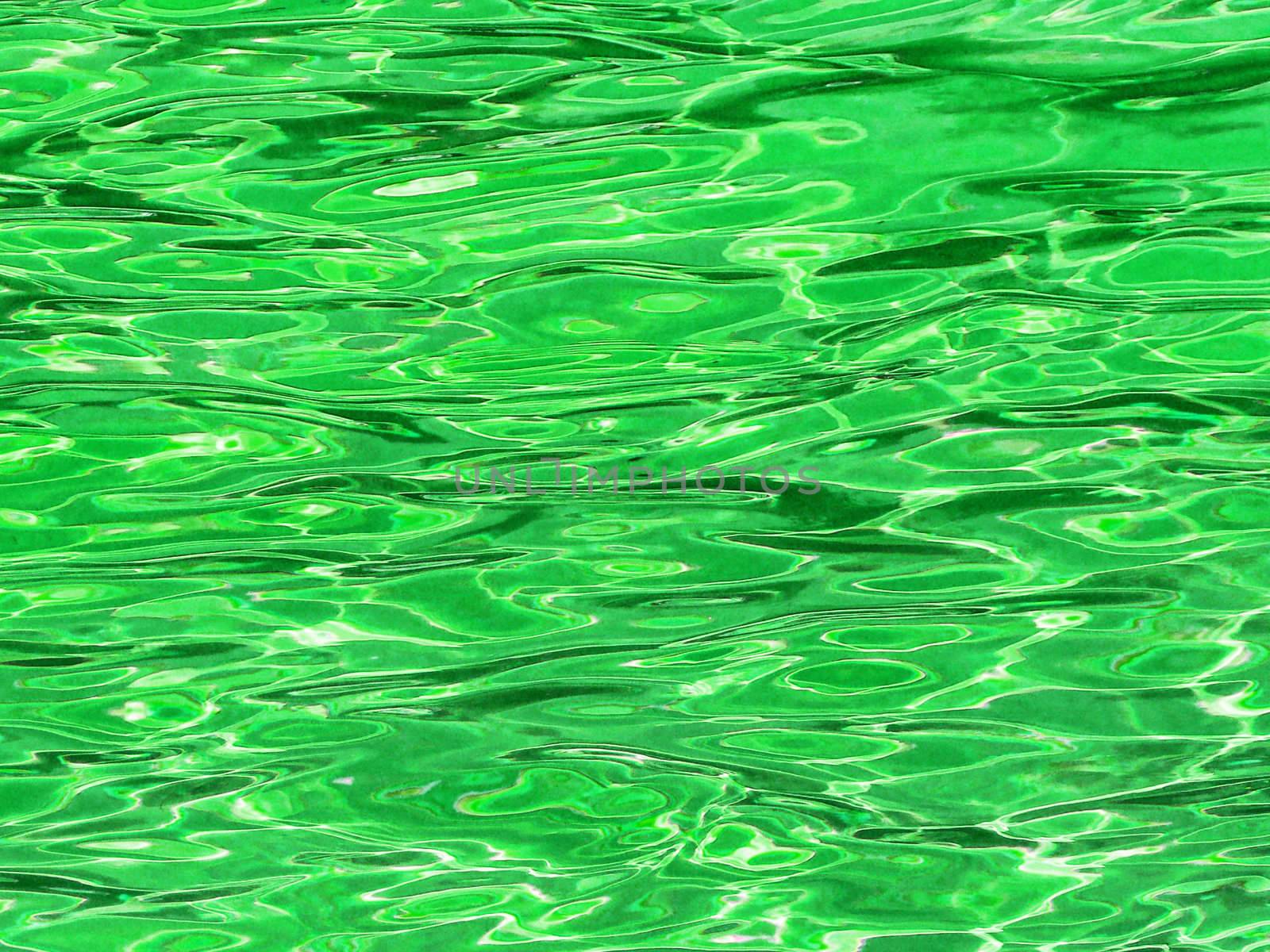 Green water background with ripple and sun reflection