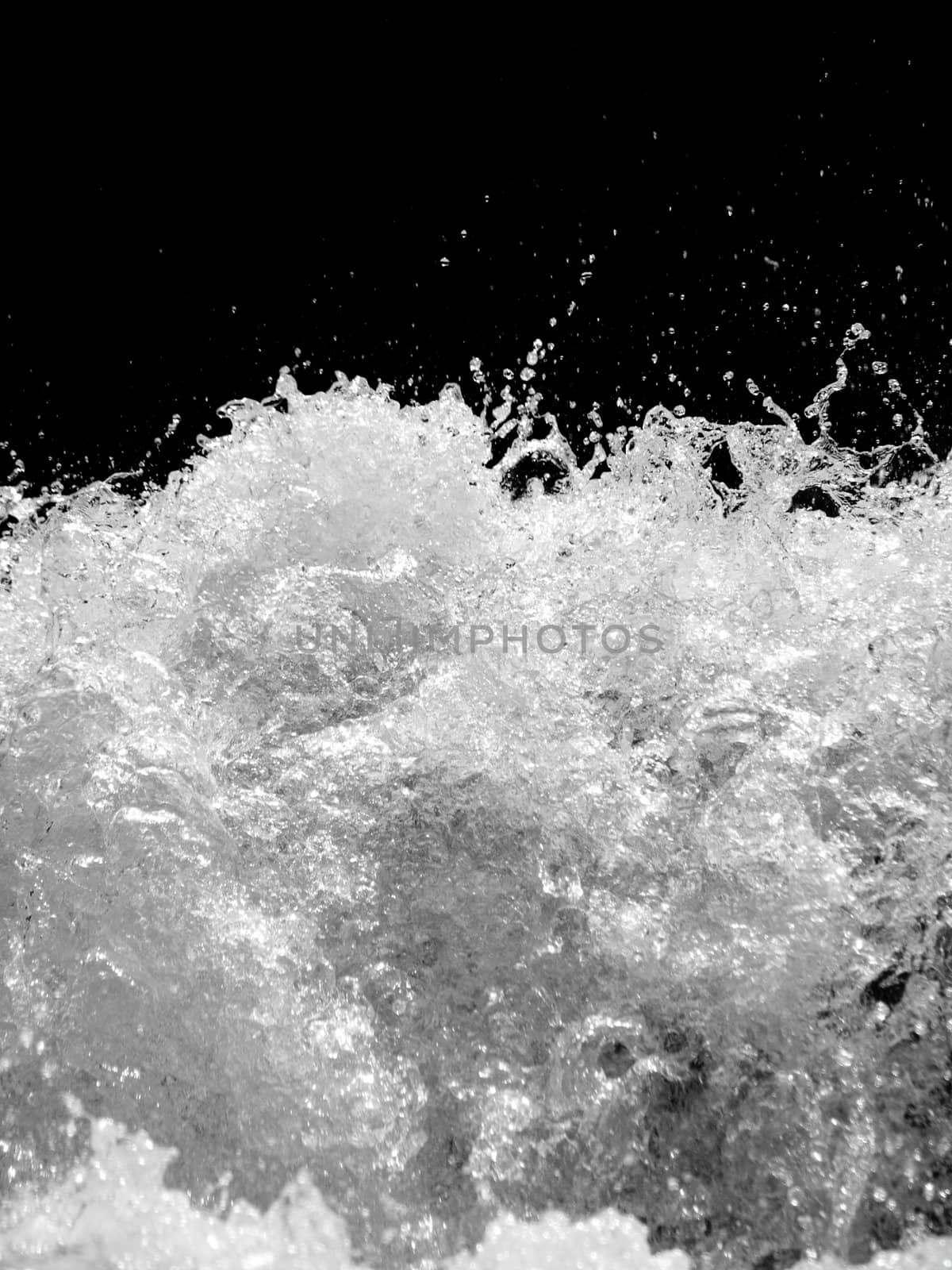 Powerful stormy river with water drops captured on black background