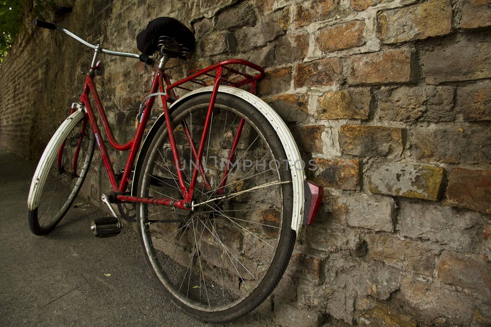 Old bicycle leaned on a brick wall