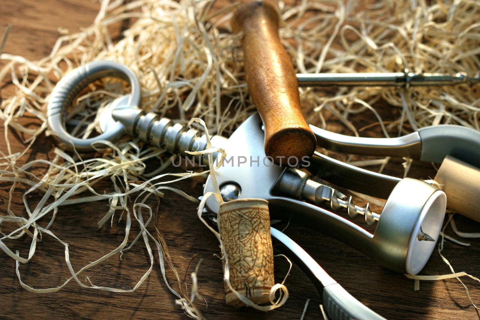 Cork screws laying on oak table with packing straw