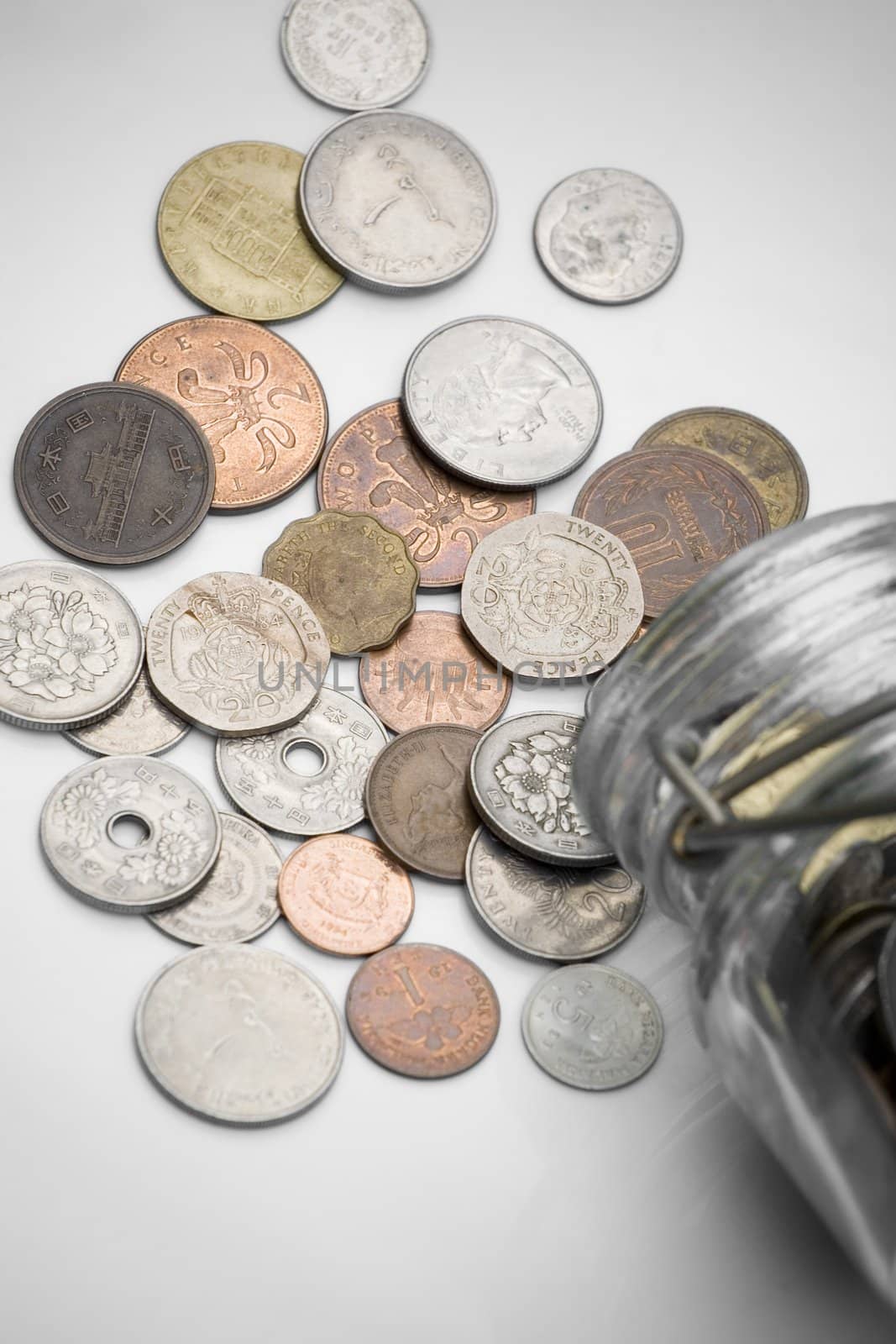 coins from various countries spilled out of a bottle