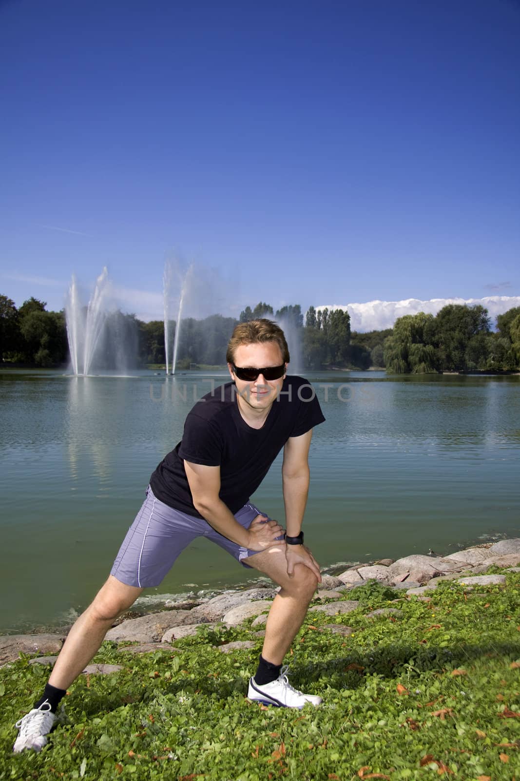 Man working out in a beautiful park by a lake