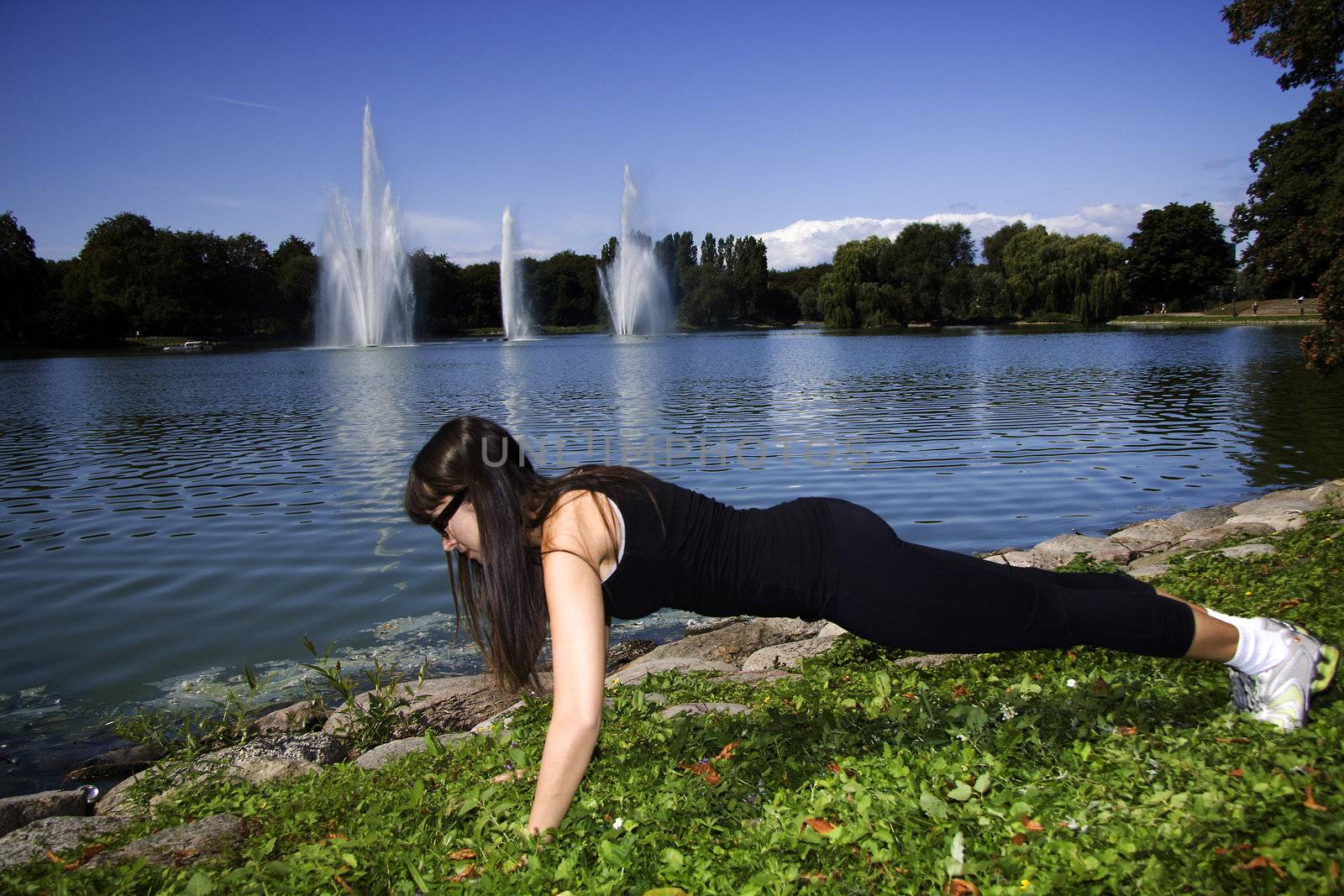 Fitness woman doing push-ups in the park by kaferphoto