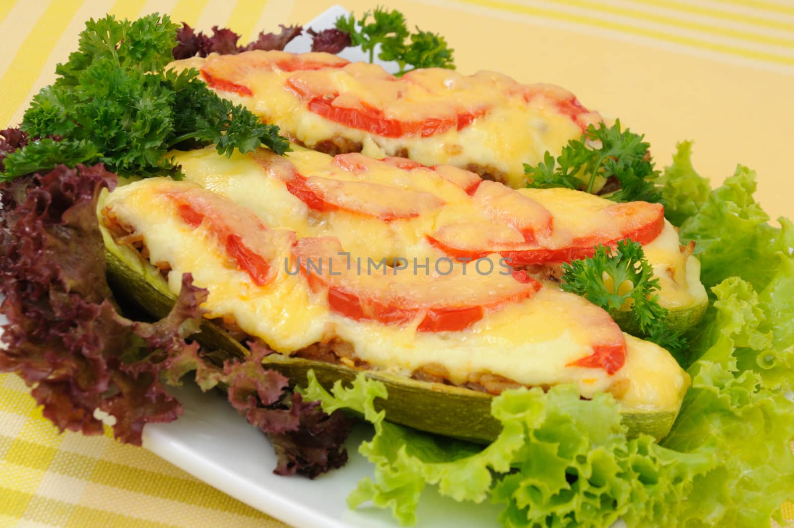 Stuffed zucchini with a mixture of vegetables with tomato and cheese with herbs