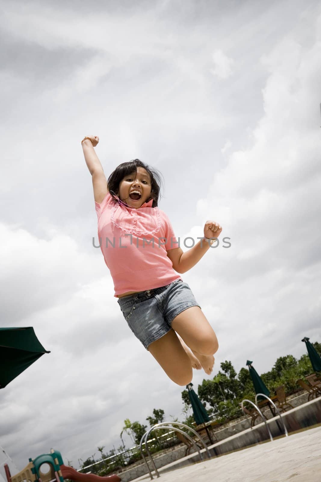 conceptual portrait of asian little girl jumping high, excited of winning some game