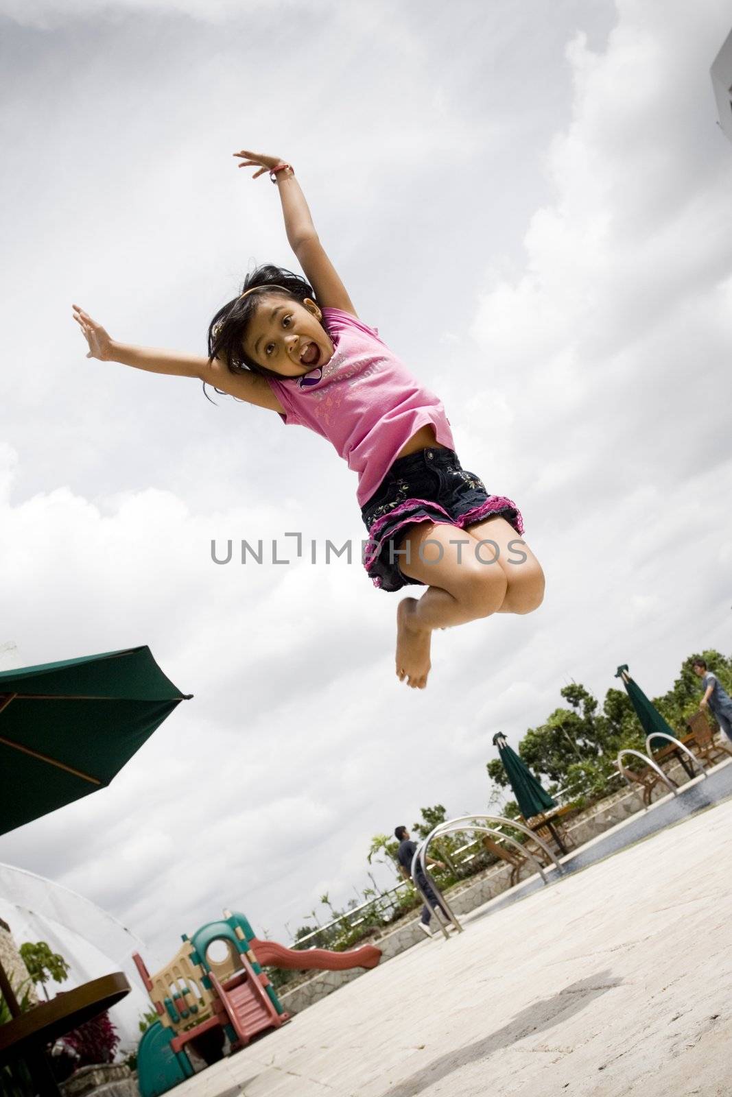 asian little girl jumping high with style, playing some dance