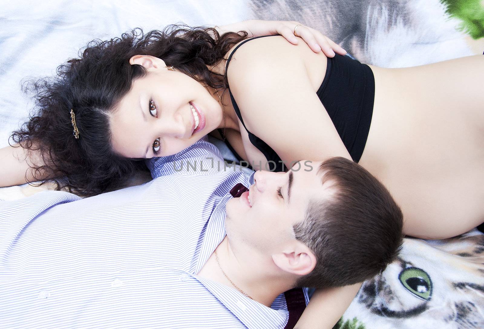 couple lays together, hugging, pregnant woman by adam121