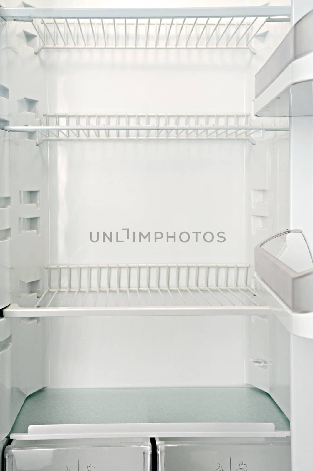 Interior of an empty open white refrigerator
