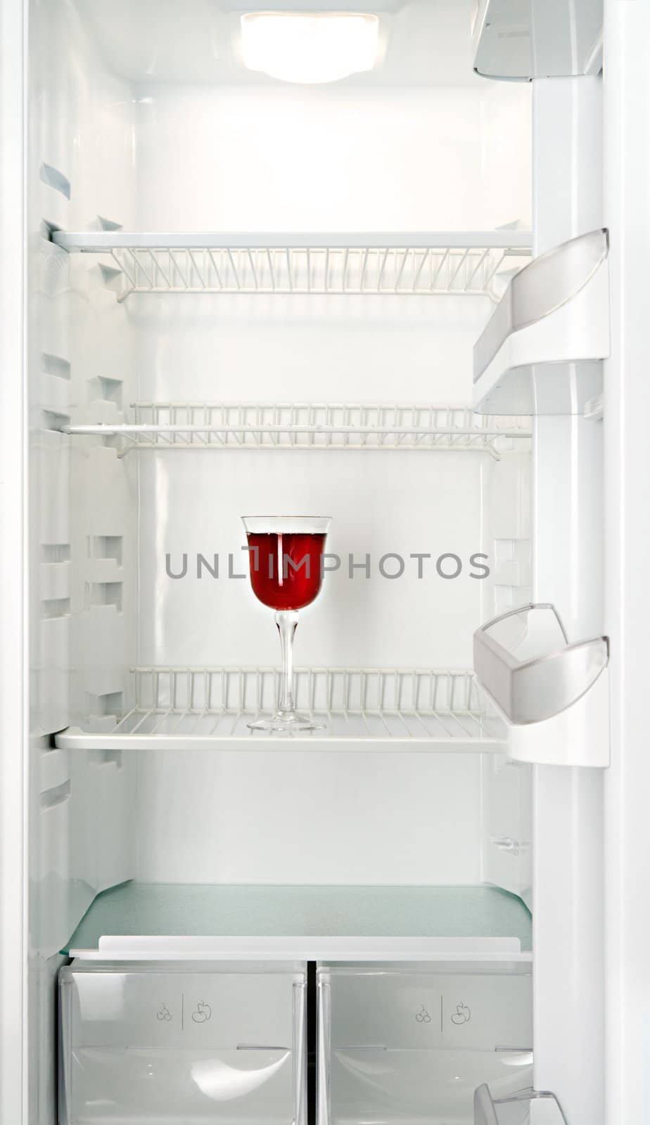 Red wine glass in a refrigerator by Gravicapa