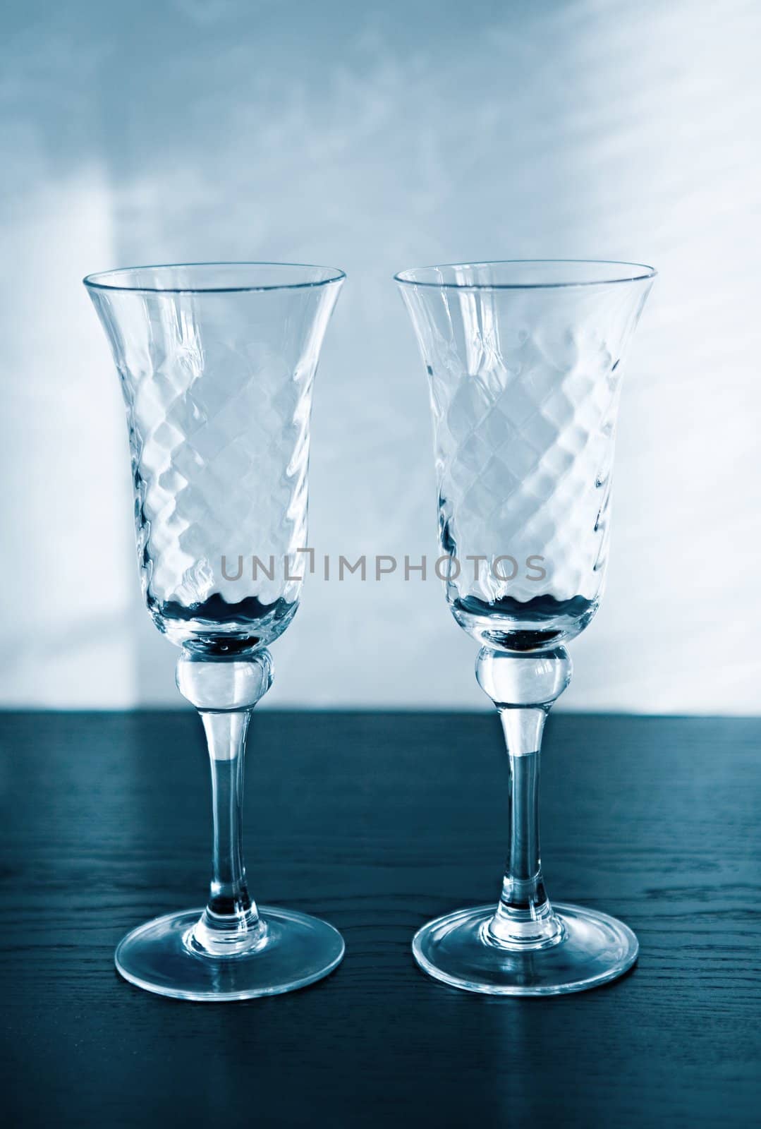 Two empty glasses for a sparkling wine stand on a black surface
