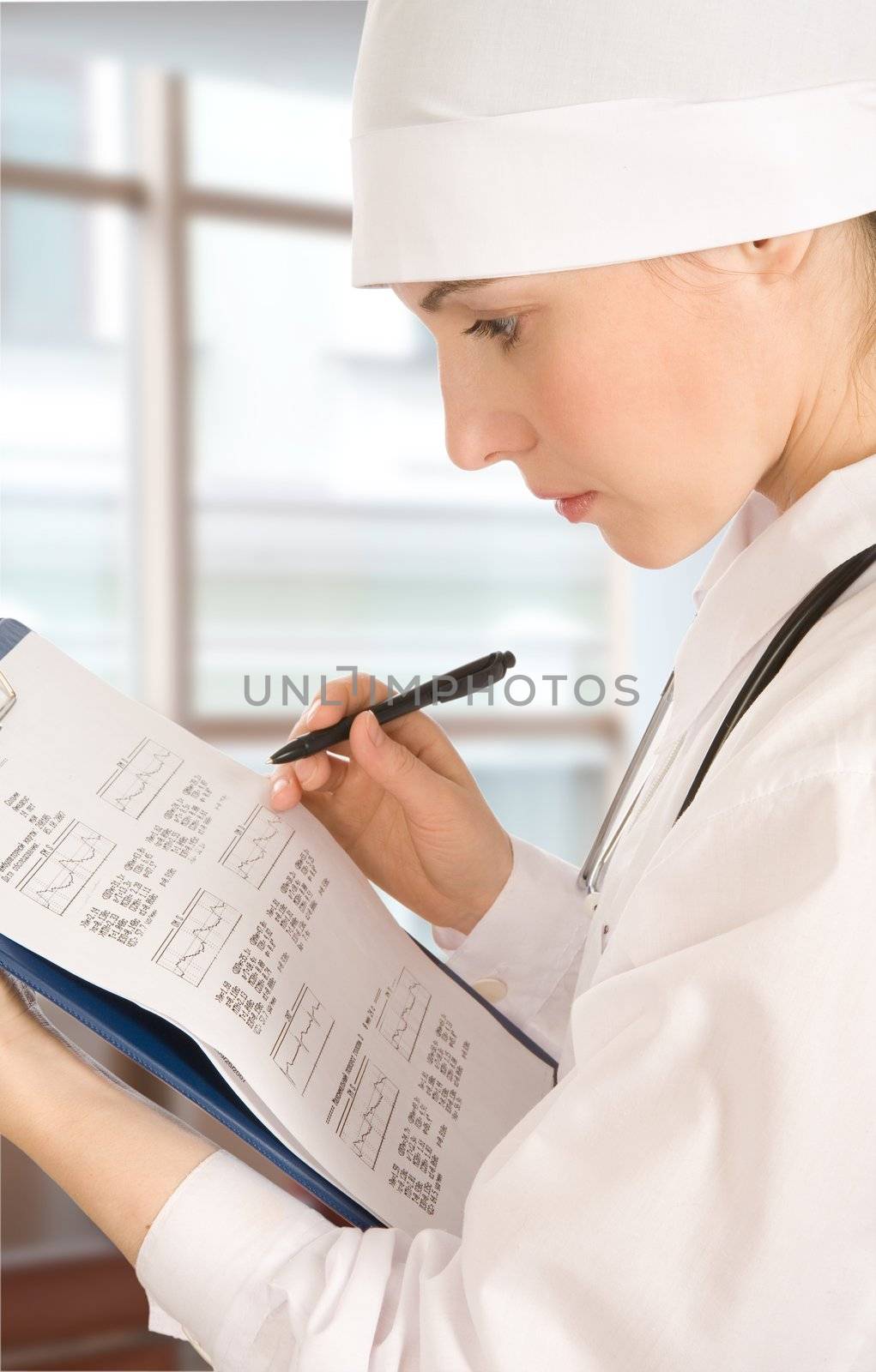 The doctor in a white jacket does records in documents by Gravicapa