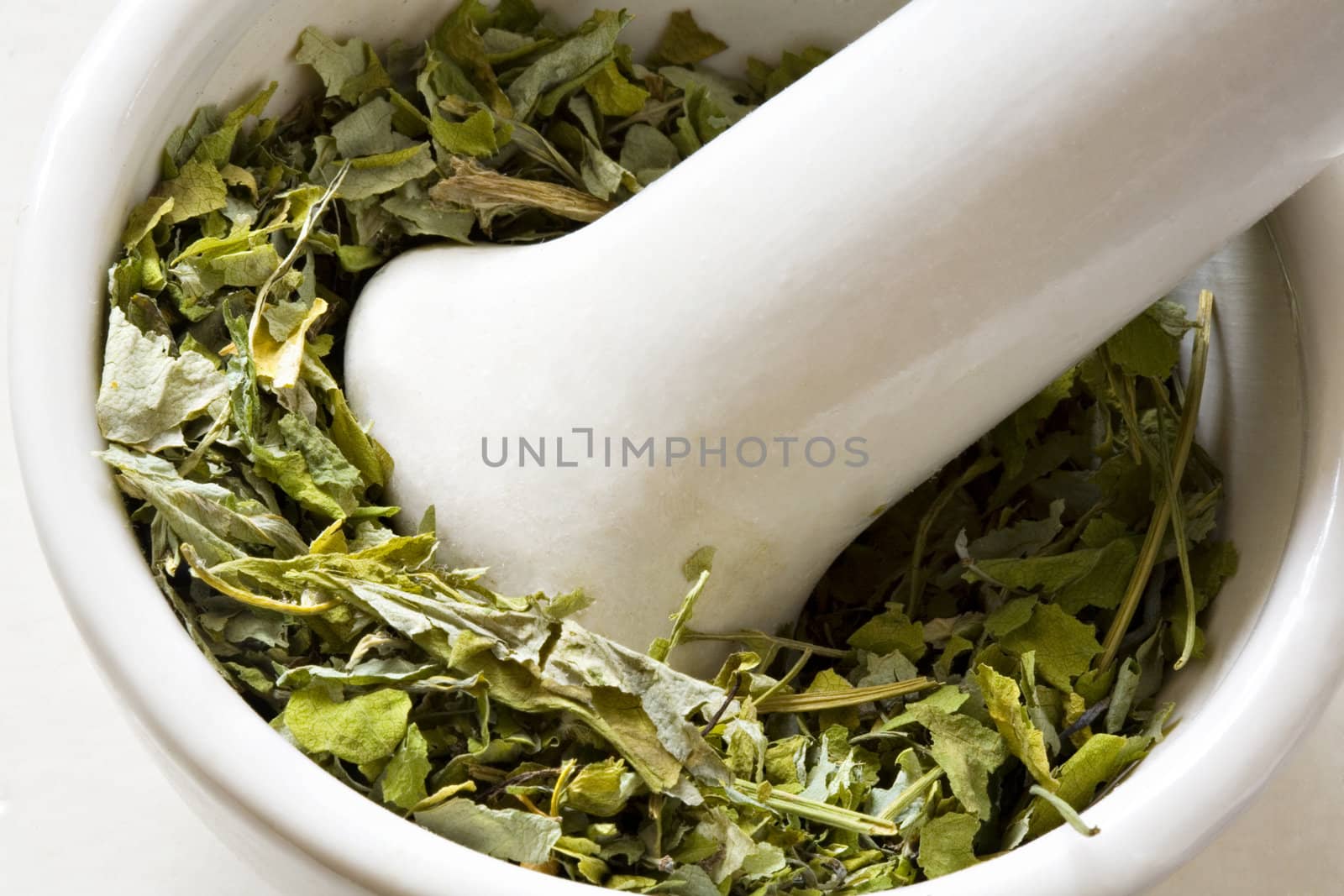 Dry leaves in a bowl in mortar with pestle close up
