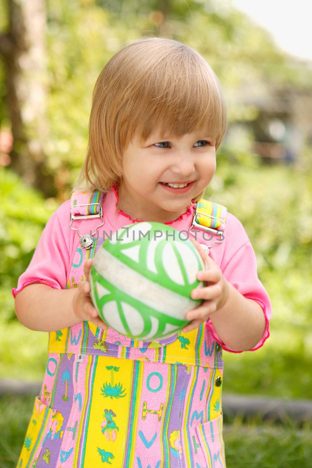 The girl holds a ball in hands