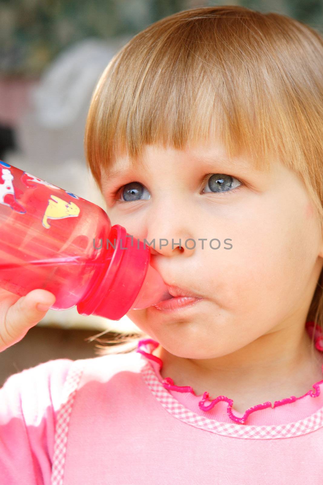 The girl drinks water from a bottle