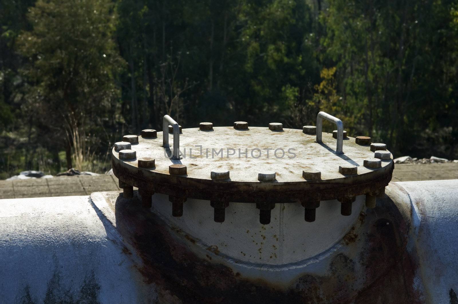 A rusty pipework cover painted in gray