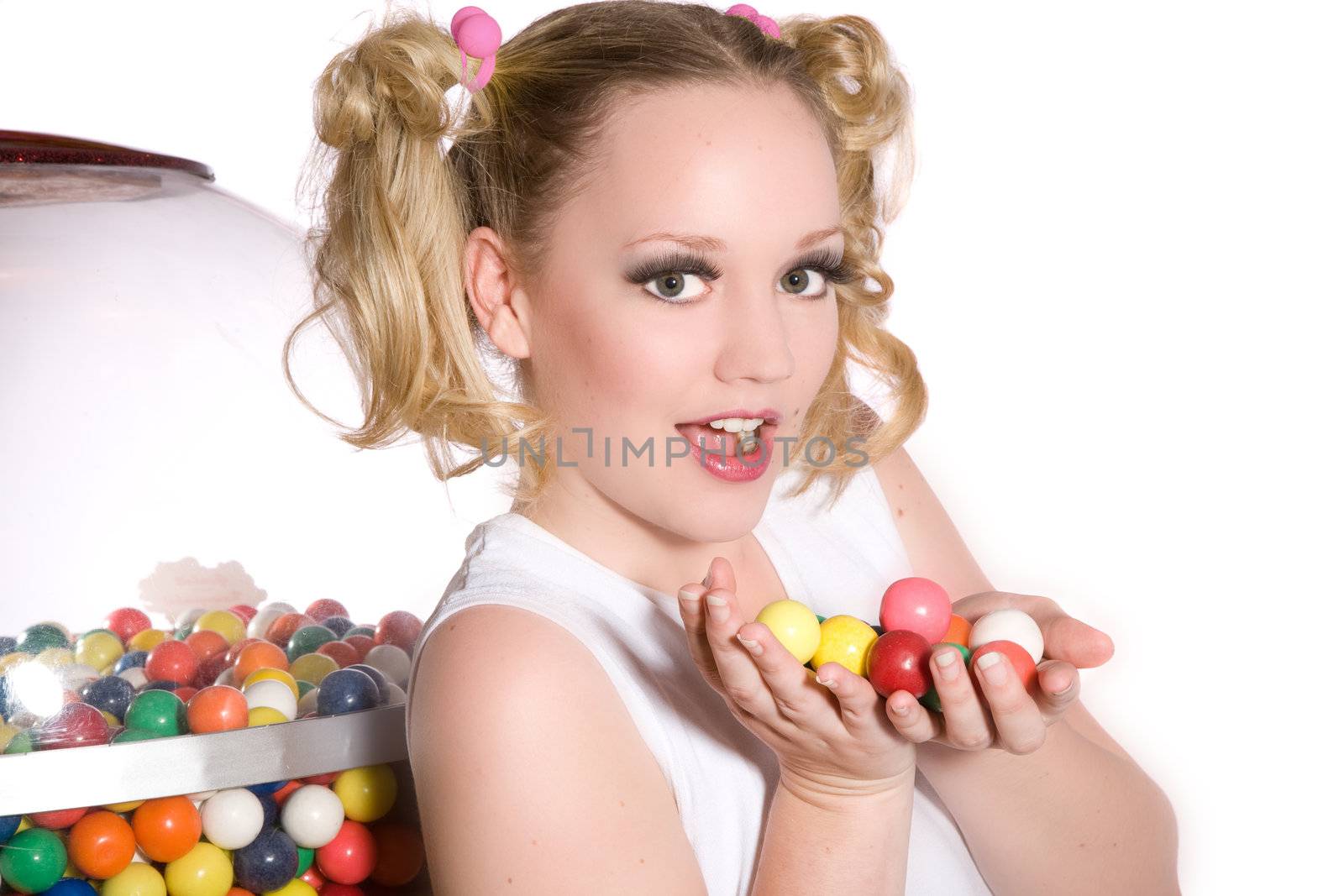Cute schoolgirl with ponytails and her hands full of chewing gum balls
