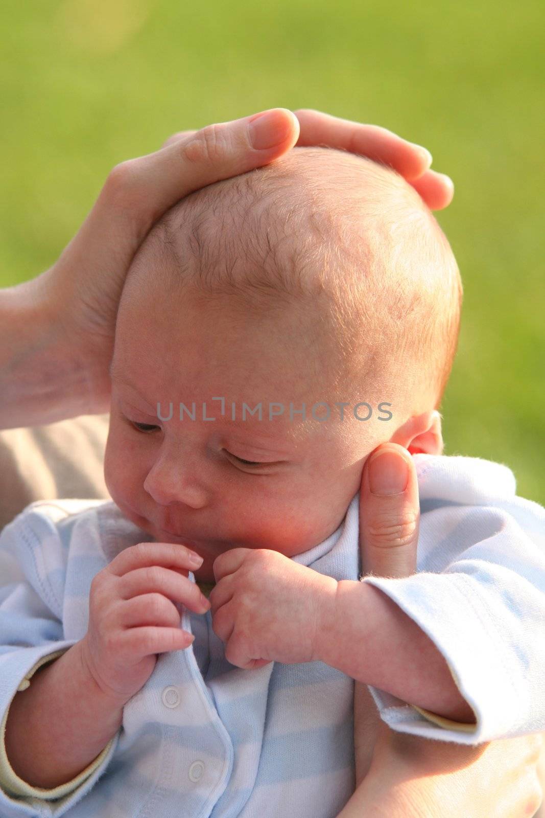 One month baby with the hand of his mother on his head