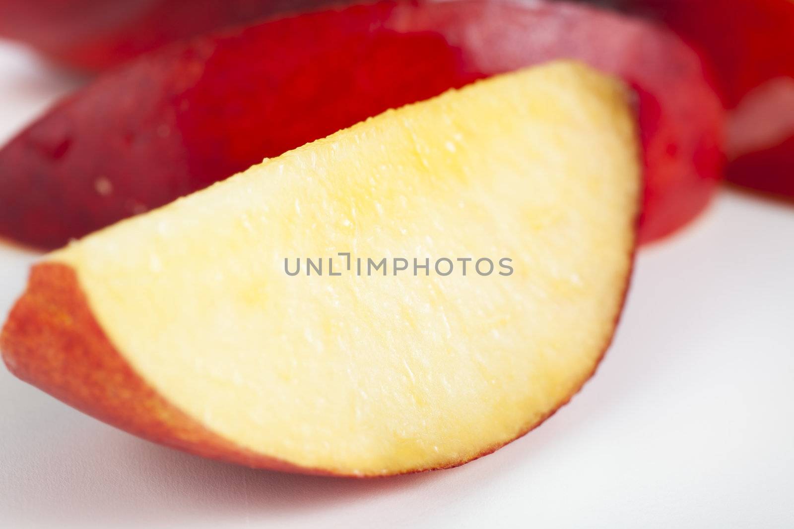 Slice of fresh nectarine, closeup with shallow depth of field.