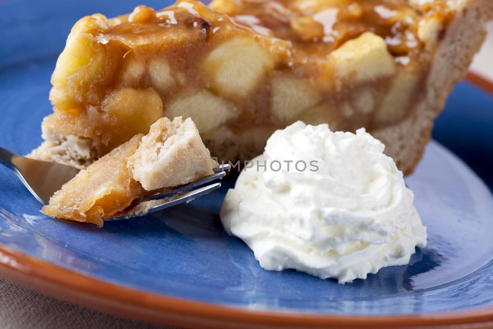 Slice of fresh homemade apple pie with whipped cream.