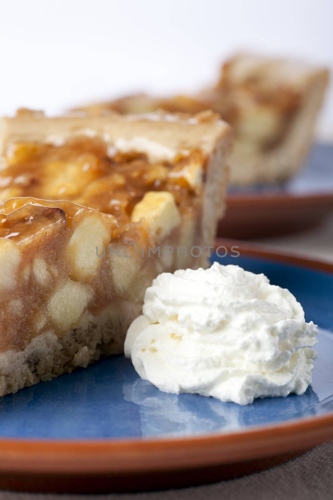 Slice of fresh homemade apple pie with whipped cream.