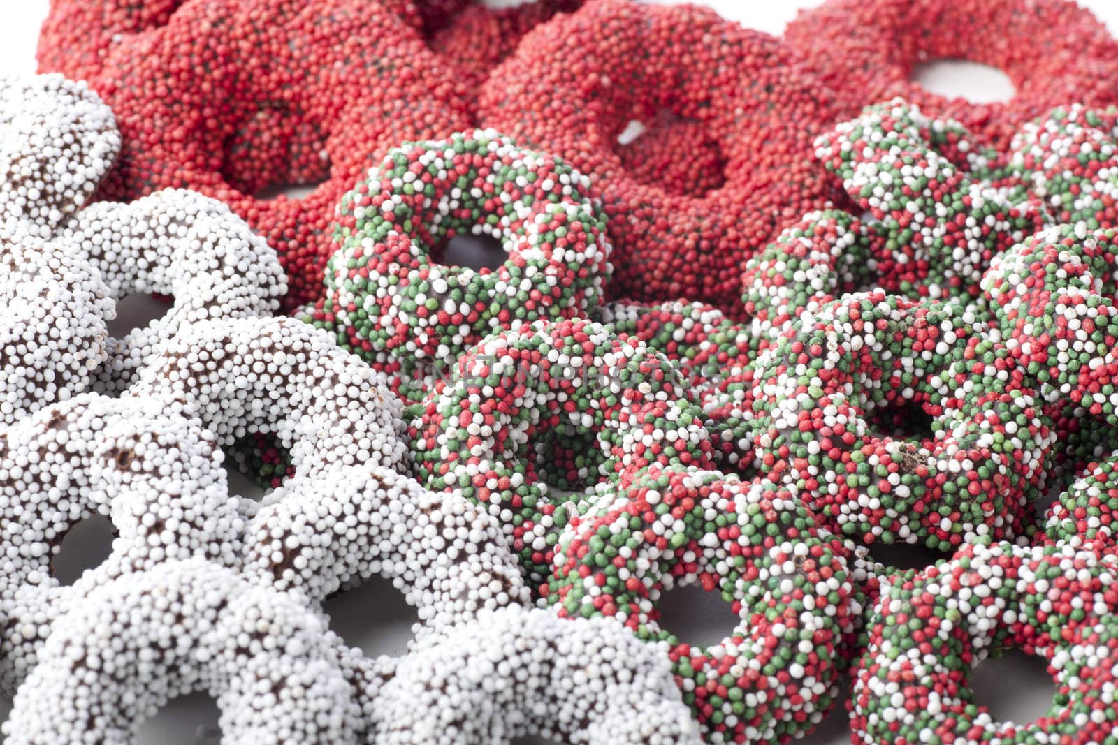 Christmas chocolates covered in red white and green candy decorations.