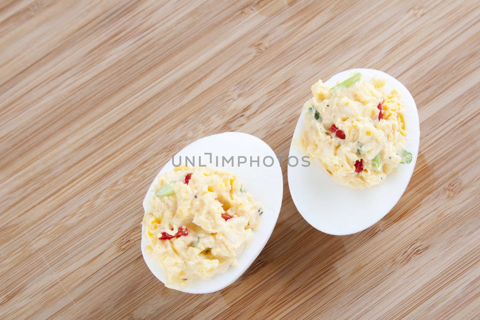 Two fresh gourmet deviled eggs on a table.