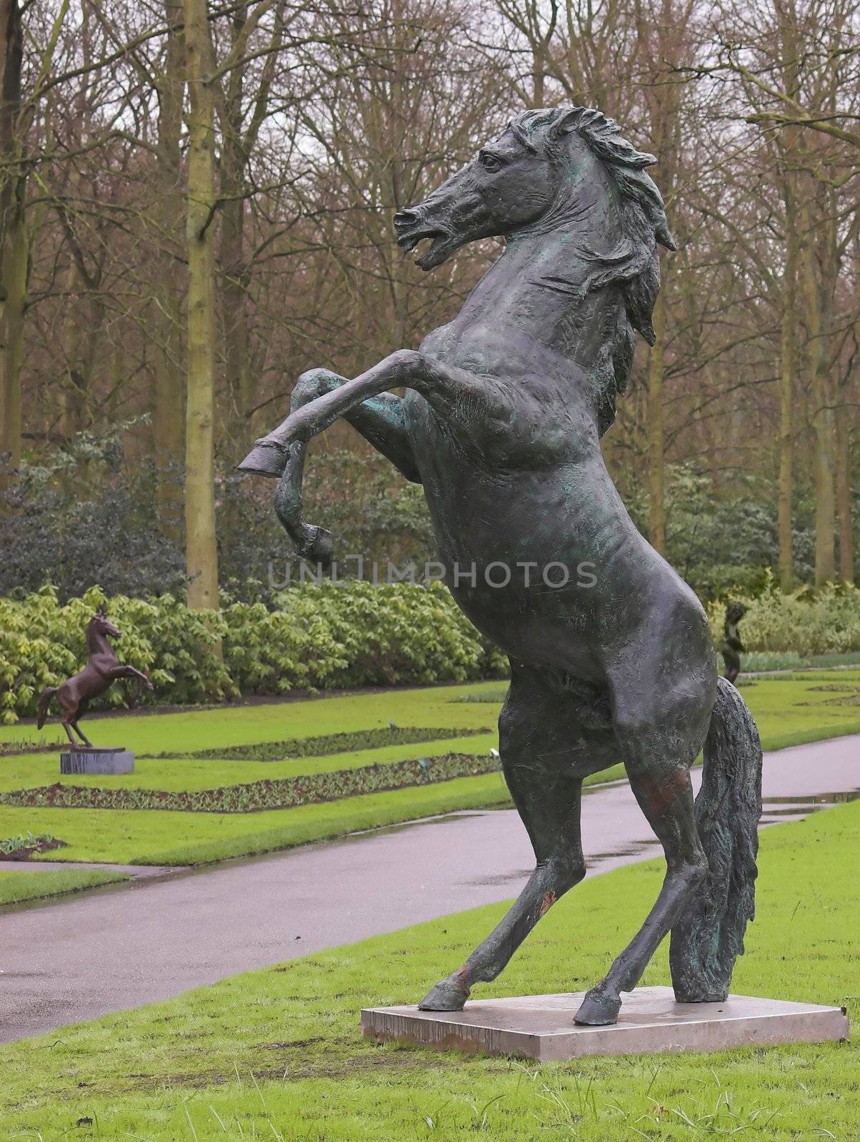 Statue of a horse standing on it's back legs in a park