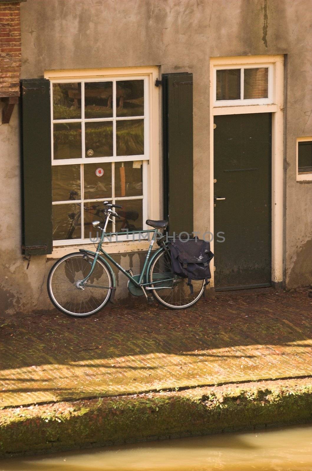 Bicycle parked at the edge of a canal in Utrecht