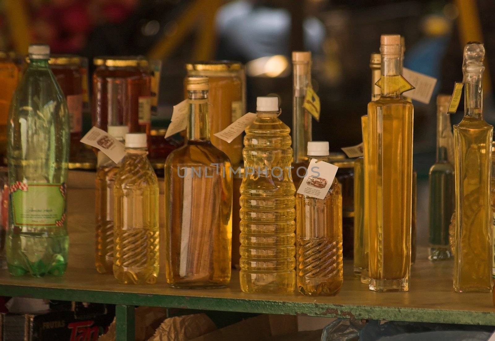 Bottles of apple vinegar, rakija and oil standing on a fair