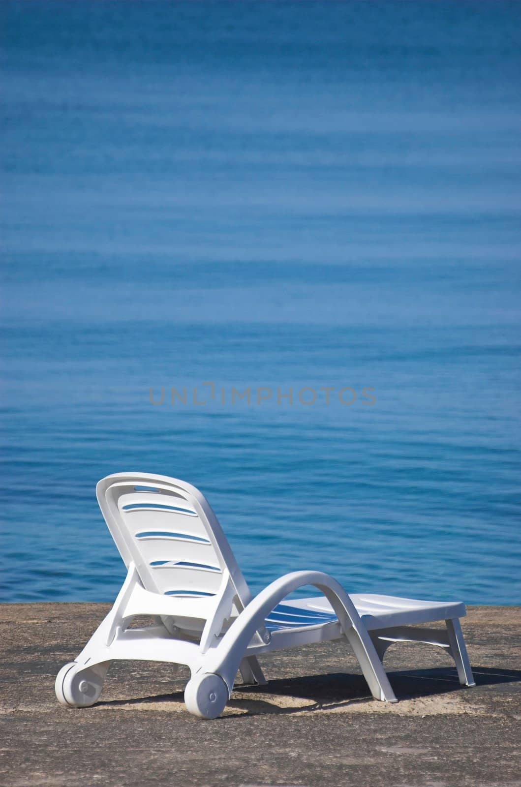 Plastic beach chair at the edge of a sea