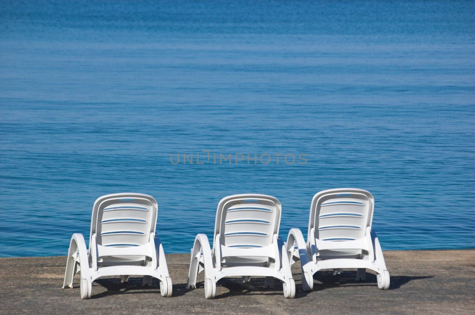 Plastic beach chair at the edge of a sea