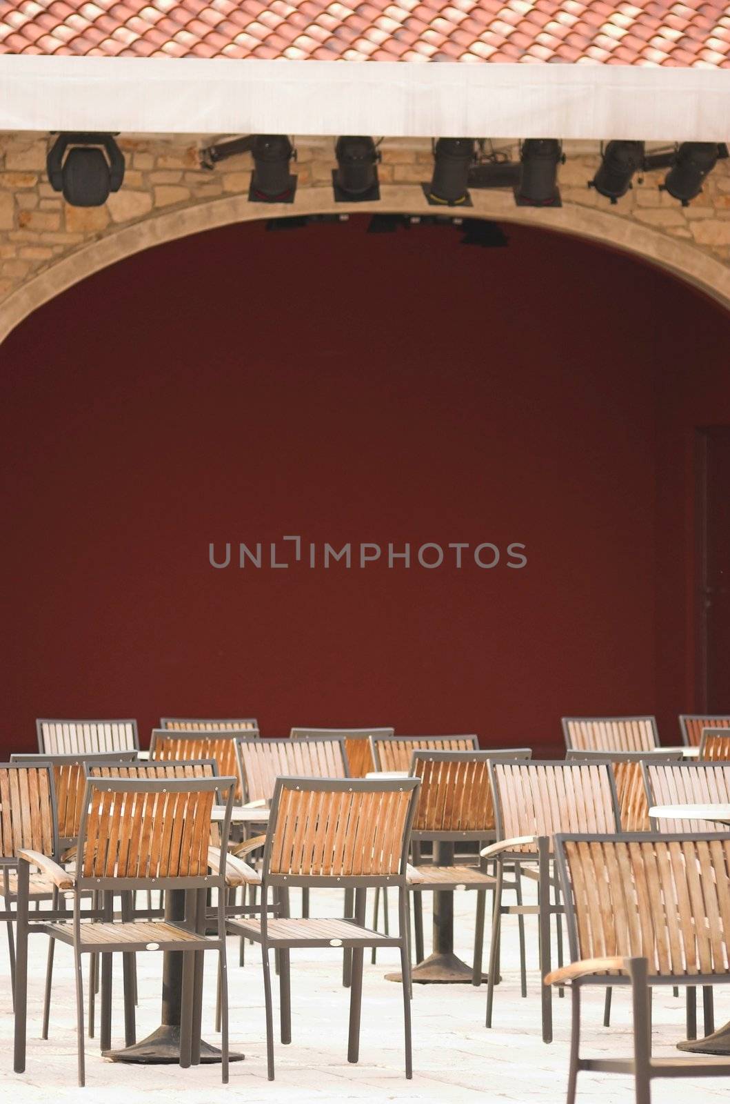 Cafe terrace filled with chairs next to a theatre scene