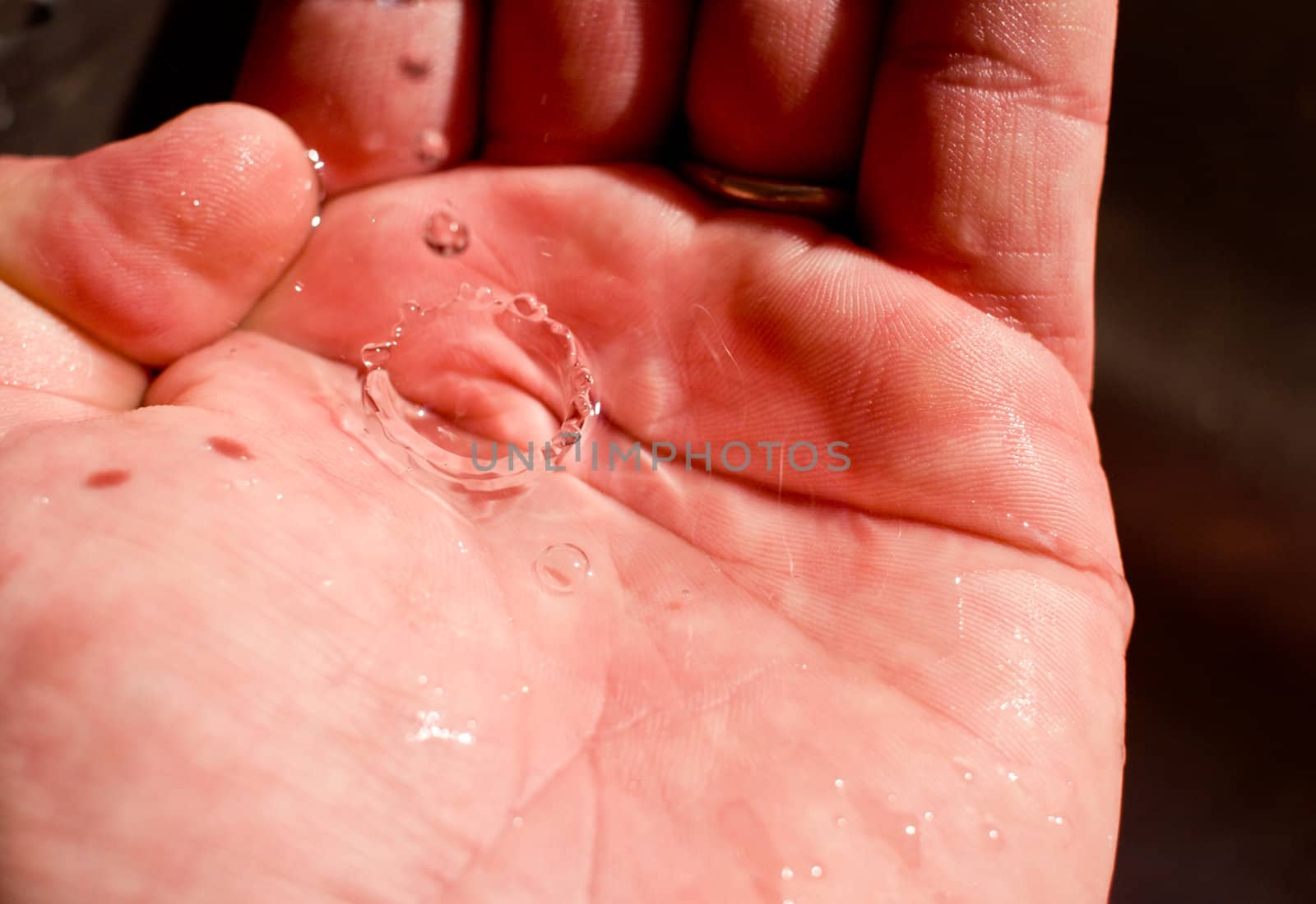 A water drop is caught in the hand. Clean drinking water is a precious resource.