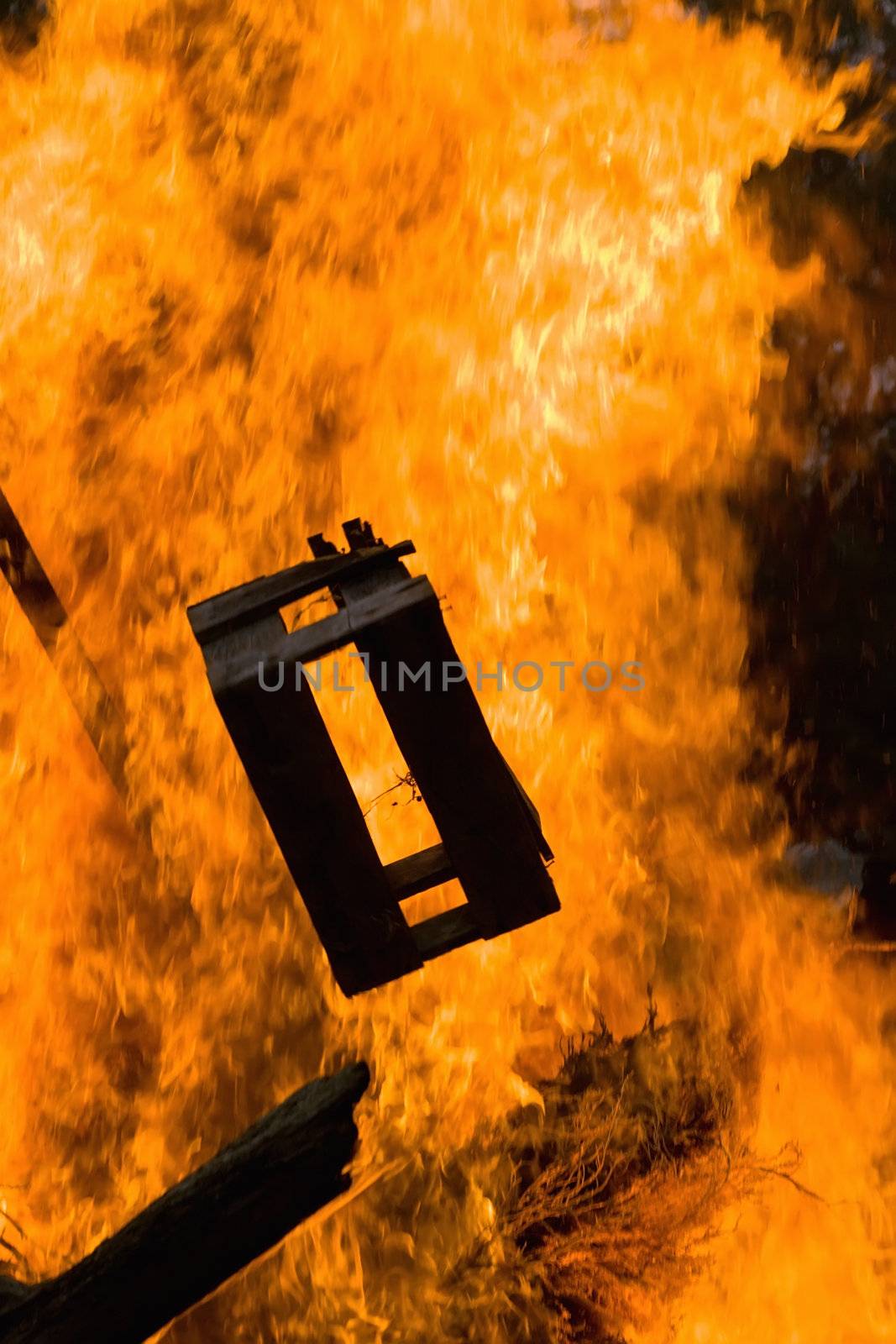 A beer crate is hurled onto a bonfire, adding fuel to the fire