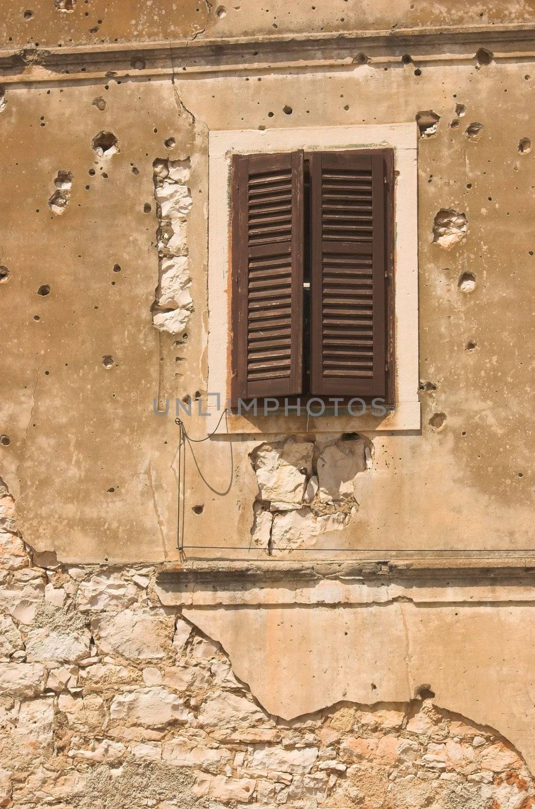 Old building facade in Croatia spotted with bullet holes