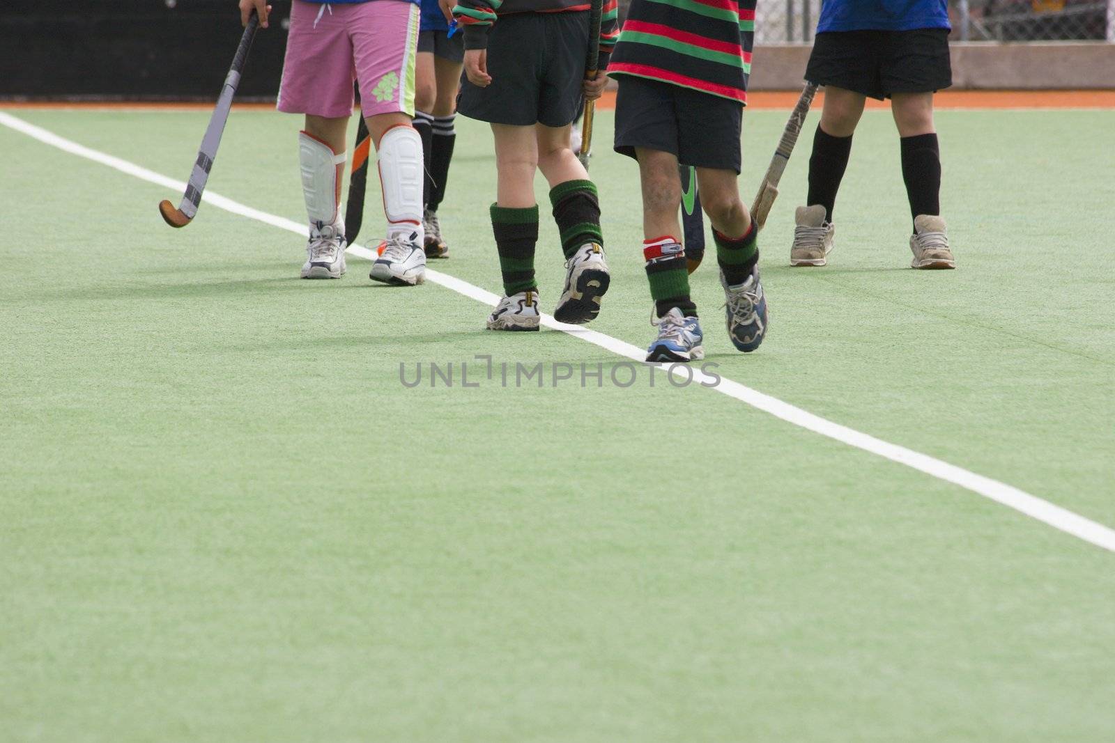 Kids standing on artificial turf playing hockey