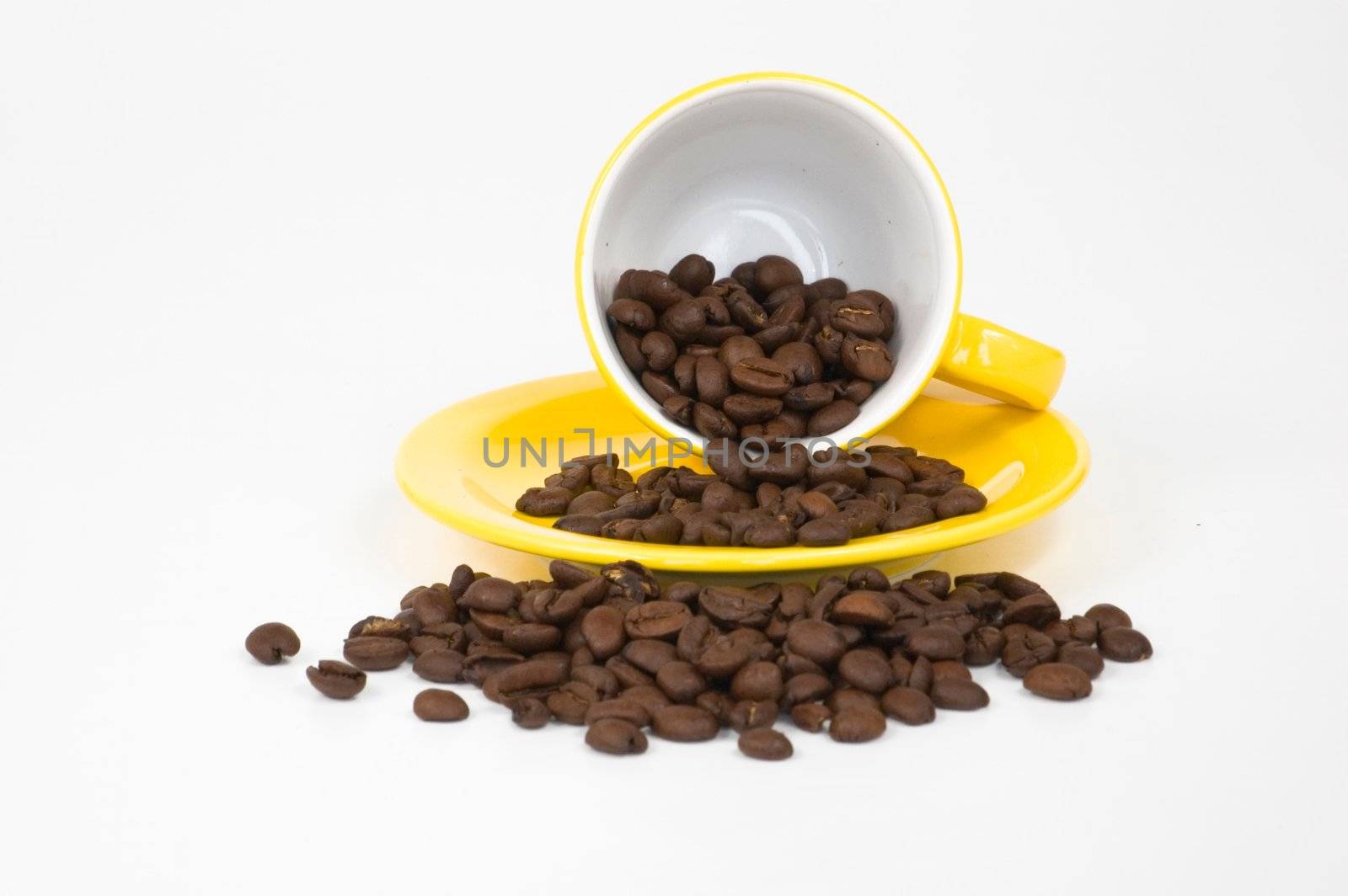 Yellow espresso cup filled with coffee beans