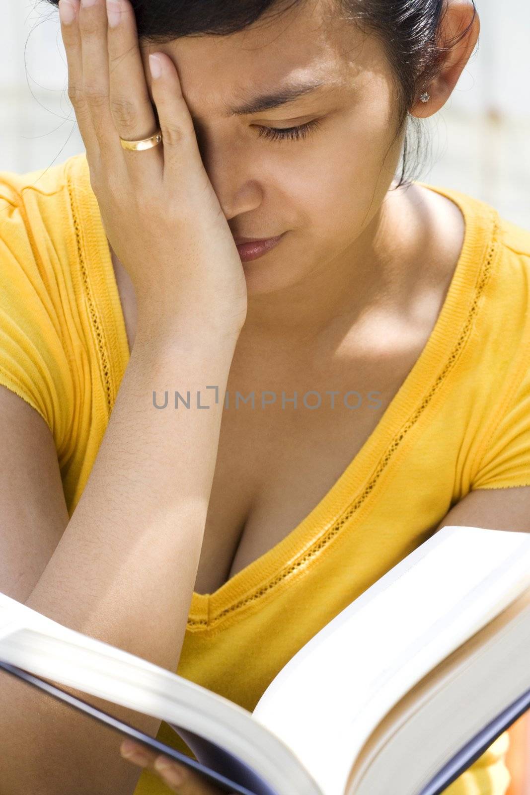 asian young woman feel dizzy while reading a book outdoor