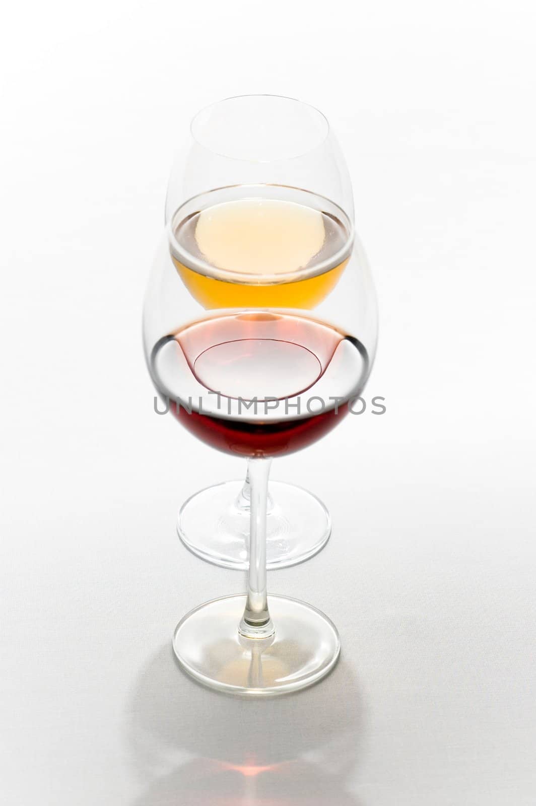 Two tall glasses isolated on white filled with red and white wine