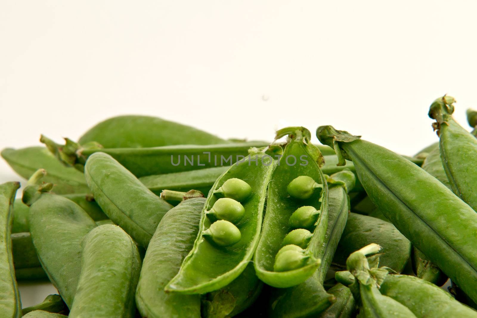Bunch of green peas  with one open pod.