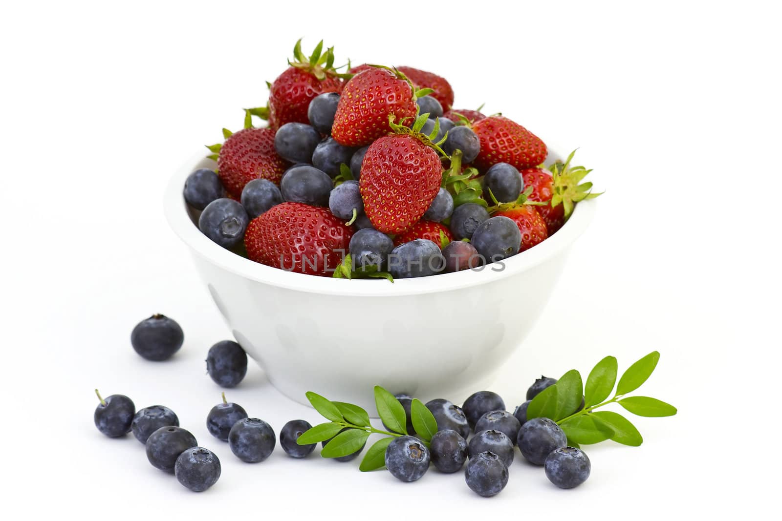 Strawberries and blueberries in a white bowl