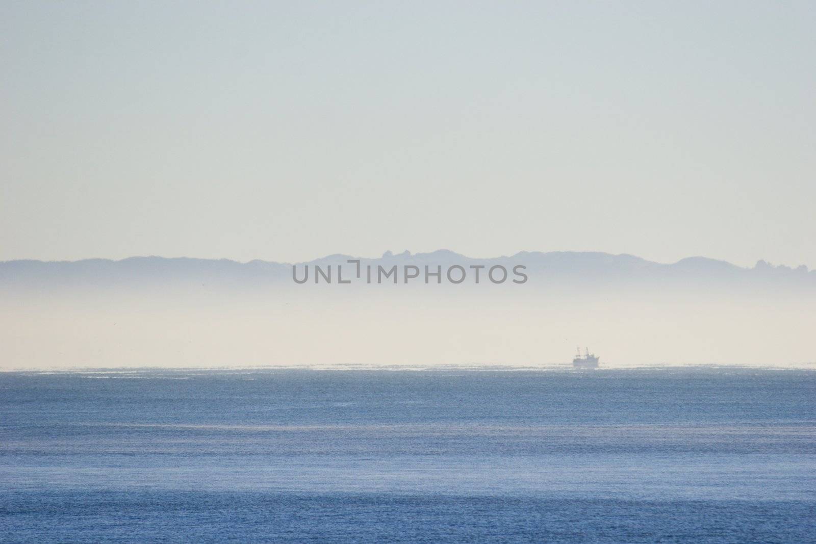 Mist over the ocean with a fishing boat