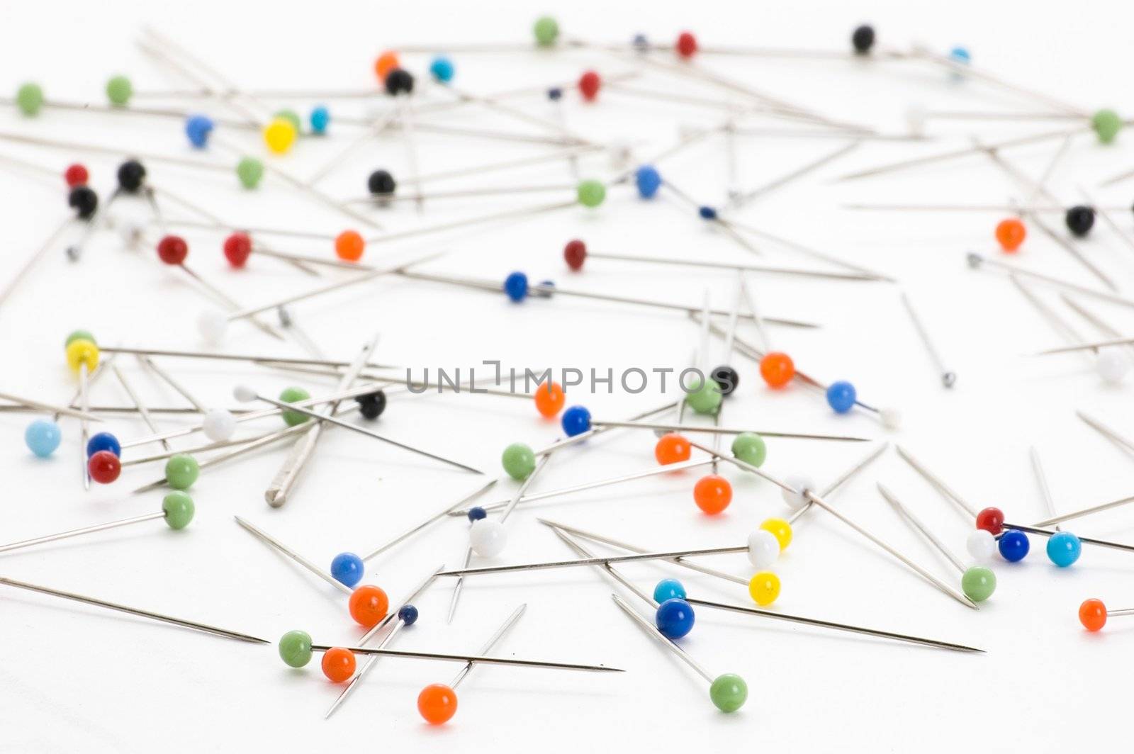 Handful of steel pins with colorful heads isolated on white