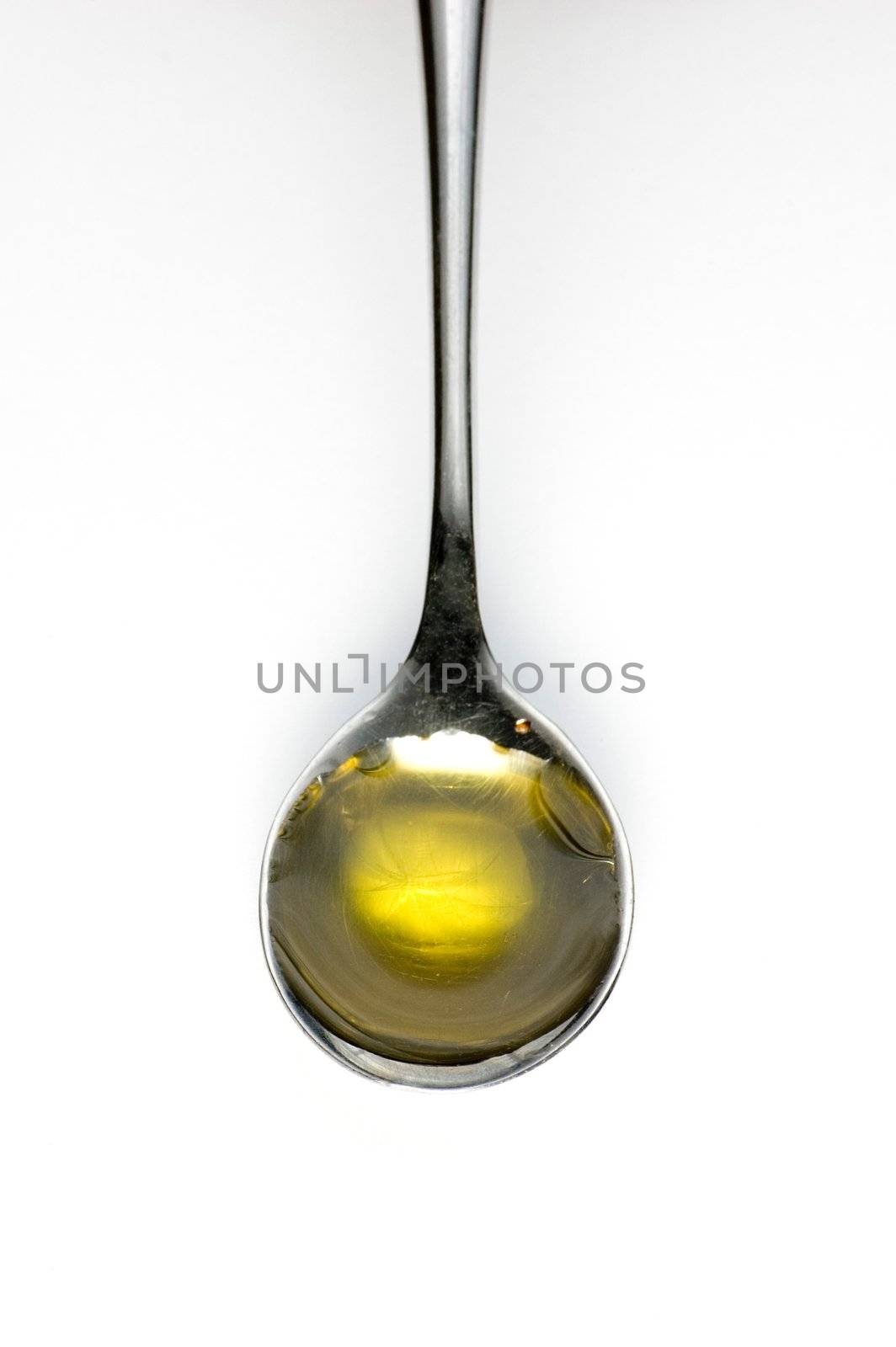 Teaspoon of olive oil isolated on white