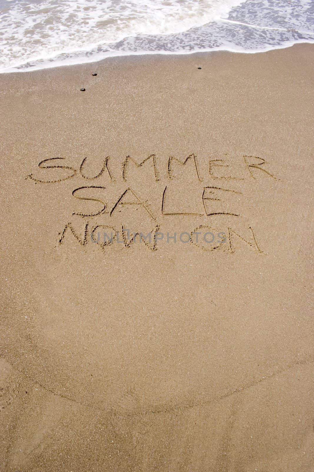 A summer sale written in the sand