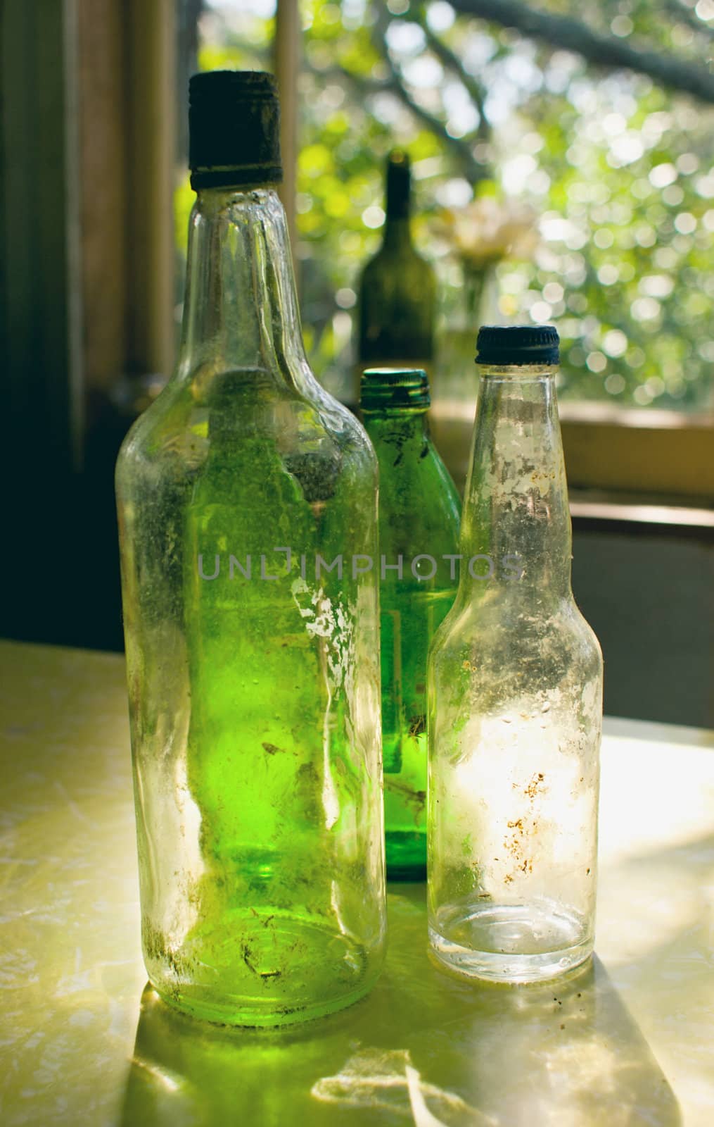 Old glass bottles sit on a formica table in a bach on Rangitoto Island