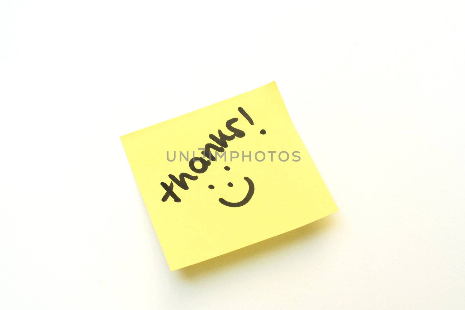 Thank you with a smile on a yellow post it note